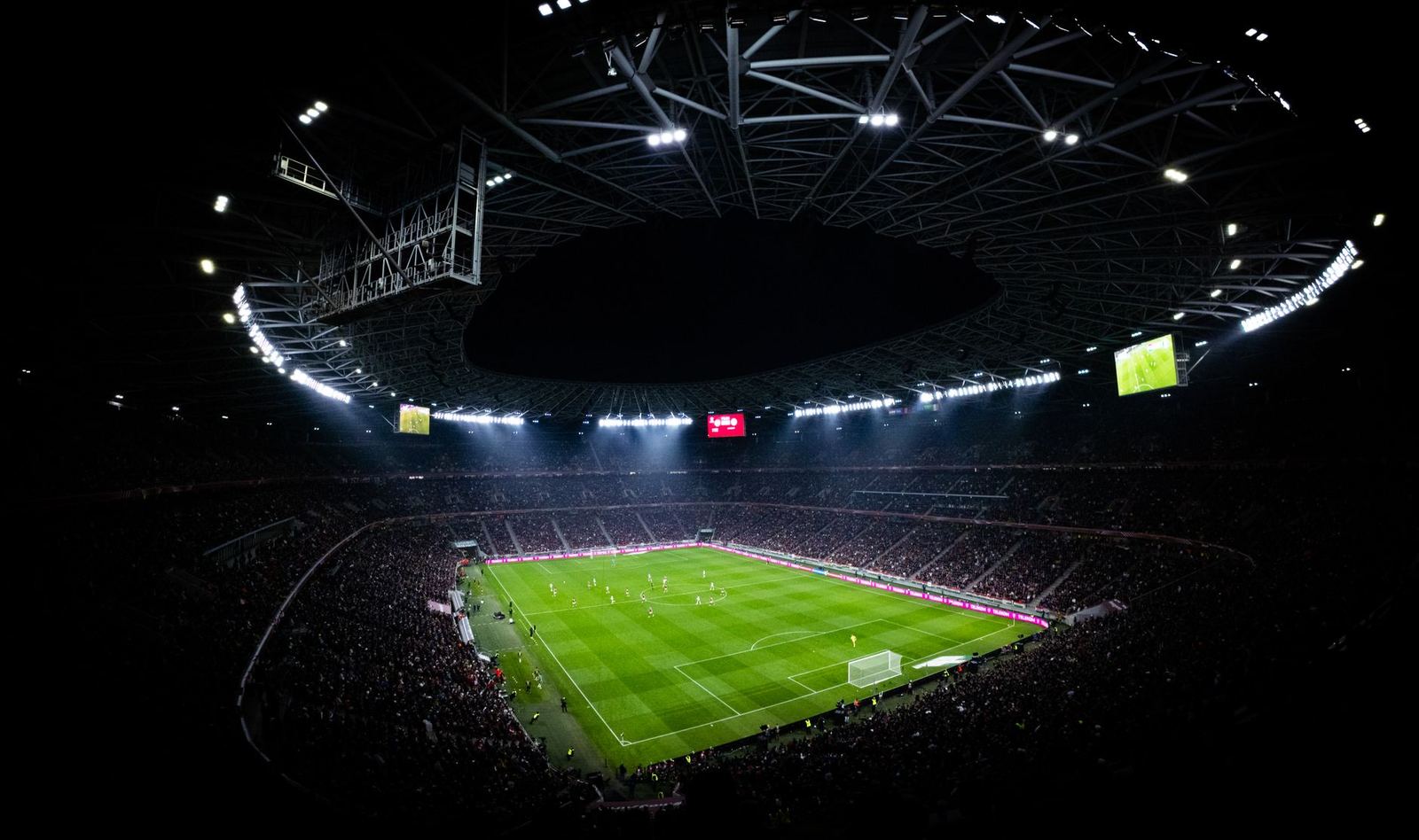 A stadium crowd under floodlights at night